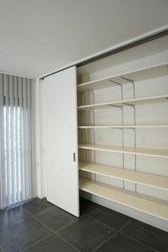 an empty room with shelves and sliding doors