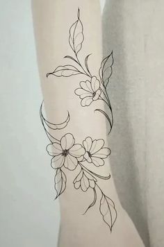 a woman's arm with flowers and leaves drawn on the back of her leg