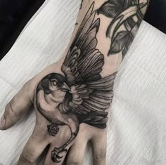 a hand with a bird tattoo on it