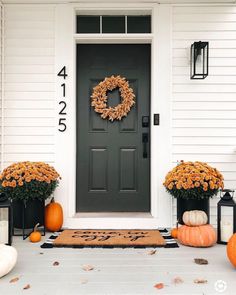 front porch decorated for fall with pumpkins and wreath