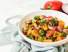 a white bowl filled with vegetables on top of a table