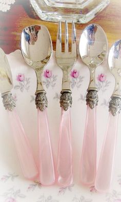 four forks and two spoons with pink flowers on them