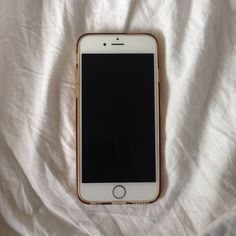 an iphone laying on top of a white sheet