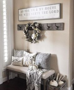 a bench with pillows and blankets on it in front of a sign that says as for me and my house we will serve the lord