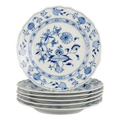 six blue and white plates stacked on top of each other, with flowers in the middle