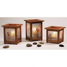 three wooden lanterns with flowers and leaves on them