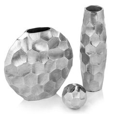 two silver vases sitting next to each other