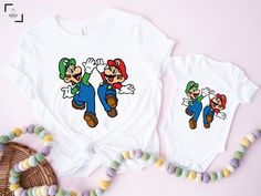 "Mario And Luigi Shirt, Mario Shirt, Cute Mario And Luigi Shirt, Super Mario Shirt, Birthday Gift, Retro Game Shirt,Gift for Gamer,Video Game Hello there! Welcome to our store SerixDesign, we are glad to see you here. The main purpose of our store is to make you happy. We see you as a friend, not just a customer. If you have any questions or would like to purchase a custom design, please contact us. We are sure you will like our designs. We will try our best to make you satisfied. HOW TO ORDER YOUR SHIRT? 1-) Please Check and Review All Photos. 2-) Choose your T-Shirt Size and T-Shirt Color from the drop-down menus. 3-) Choose your amount as much as you want. 4-) Click the ADD TO CART button. You can return or complete the checkout process to add more product colors for your family members White Shirt With Character Print Gift, White Shirt With Cartoon Print As Gift, White Tops With Cartoon Print Matching Style, Super Mario Shirt, Mario Shirt, Gift For Gamer, Retro Game, Video Gamer, Mario And Luigi