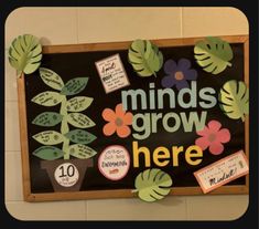 a bulletin board that says minds grow here with lots of leaves and flowers on it