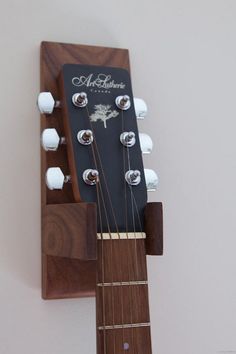 an acoustic guitar hanging on the wall with its neck and frets attached to it