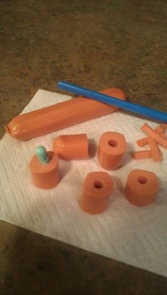 several orange objects are sitting on a piece of paper with a blue pencil next to them