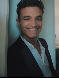 a man in a suit smiling for the camera