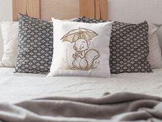 a bed with two pillows and an elephant pillow on top of it, both holding an umbrella