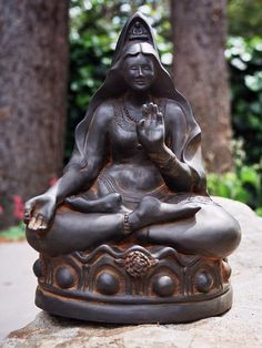 a buddha statue sitting on top of a rock