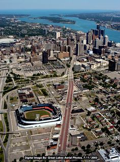 an aerial view of a city with lots of tall buildings and water in the background