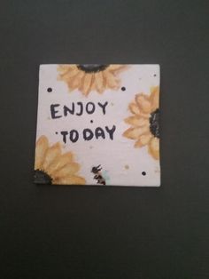 a piece of paper with the words enjoy to day written on it and sunflowers