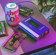 a table topped with cassettes and a can of soda