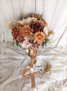 a bridal bouquet on a bed with white sheets