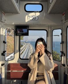 a woman taking a photo in the back of a bus