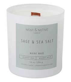 a white candle that is sitting in front of a white background with the words sage and sea salt on it