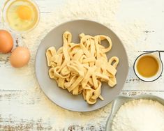 pasta and eggs on a table with flour