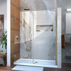 a walk in shower sitting next to a bathtub and sink with a rug on the floor