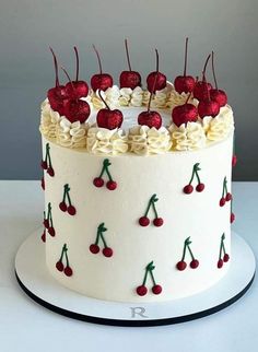 a cake decorated with cherries and white frosting