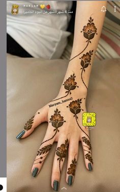 a woman's hand with henna tattoos on her arm and hands, all done in arabic