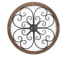 an iron and wood circular wall clock on a white background