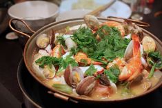 a bowl filled with seafood and clams on top of a table