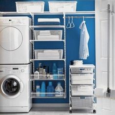 a white washer sitting next to a dryer in a room with blue walls