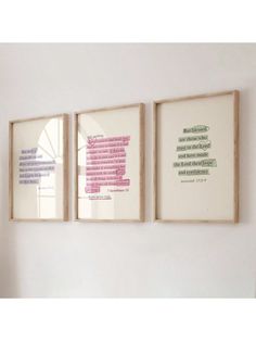 three framed art pieces hanging on the wall next to each other, with words written in different languages