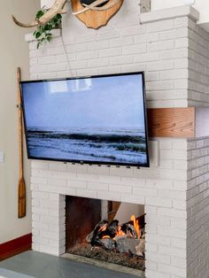 a flat screen tv mounted above a fireplace