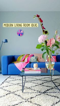 a living room with blue couches and pink flowers