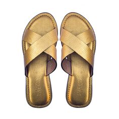 Handcrafted to perfection, these UGONNA slippers offer a bright golden twist to the classic criss-cross slippers. They are the picture of relaxed luxury and are perfect for the lady who appreciates the beauty of simplicity but who demands nothing but the best from her footwear.  Made with 100%  leather, UGONNA's golden leather straps that are surprisingly light-weight and have been lined with soft, smooth leather, to provide maximum comfort. Its anatomically padded insole provides long-lasting comfort and reduces foot fatigue, making it perfect for the stylish woman on-the-go. Its anti-slip rubber sole also provides  durability and traction. UGONNA also features a hand-sewn construction detail on the insole, which boosts its style and long-lasting durability. Gold Slippers For Summer, Elegant Gold Slide Sandals, Gold Slide Mules For Spring, Gold Slide Mules For Summer, Luxury Gold Sandals With Leather Sole, Gold Round Toe Mules With Leather Sole, Gold Slide Mules For Beach, Gold Mules With Leather Sole And Round Toe, Elegant Gold Slip-on Sandals