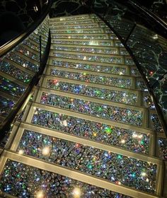 an escalator with lots of glitter on it's sides and lights shining down the side