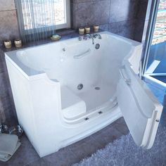 a large white bath tub sitting next to a window