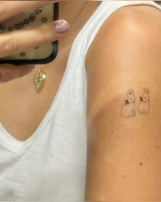 a woman with a small tattoo on her arm holding a cell phone to her ear