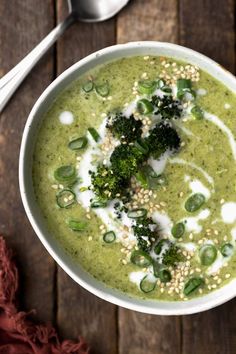 a white bowl filled with green soup and topped with broccoli