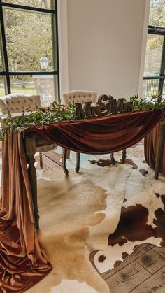 the table is decorated with greenery and mr and mrs letters on it's side