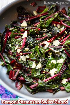 a bowl filled with greens and cheese on top of a table