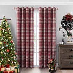 a christmas tree in front of a window with red and white checkered drapes