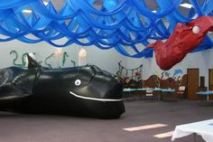 an inflatable car is on the floor with blue streamers hanging from it