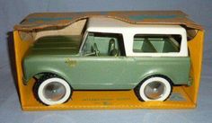 a green and white toy car in a cardboard box