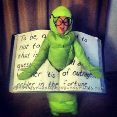 a person in a green frog costume holding a book