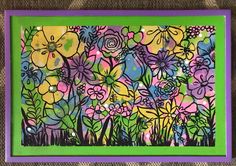 a painting with flowers painted on it in green and purple frame, sitting on a brown surface