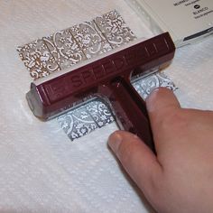 a person is using a paint roller to finish the fabric on a white tablecloth