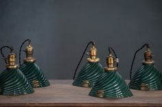 four green lamps sitting on top of a wooden table