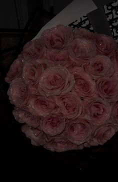 a bouquet of pink roses sitting on top of a table