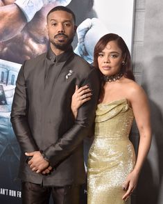 a man and woman standing next to each other in front of a poster for the movie